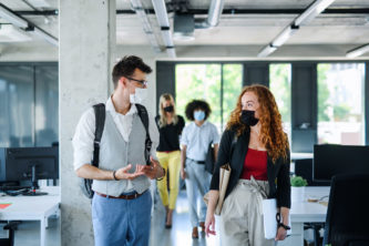 Young,people,with,face,masks,back,at,work,in,office