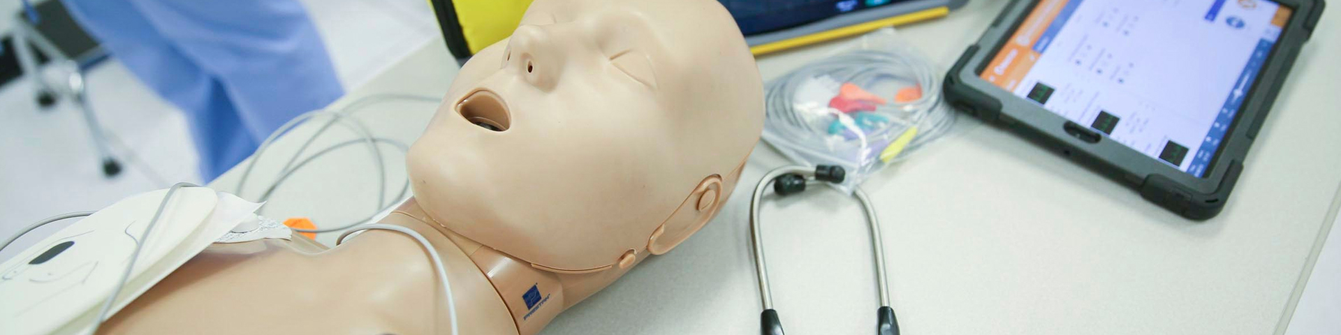 a medical simulation dummy on a table with an ipad