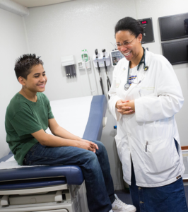 Dr. Christina Robinson preforms eye exam on young boy