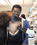 Student Looking Through A Microscope