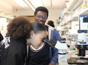 Student Looking Through A Microscope