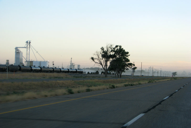 a photo of a dusty road running alongside a train track