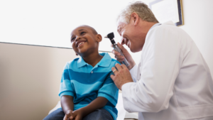 Pediatrician performing an ear examination with a child