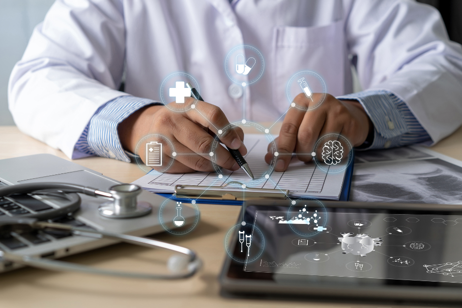 health professional writing in a chart behind a virtual suspended health graphic in front of a laptop and tablet