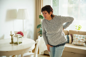 a woman indicating pain in her lower back